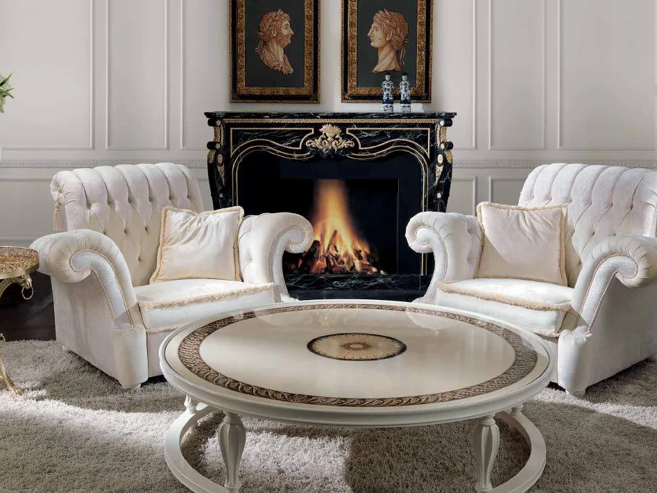 Luxury III catalogue: white tufted armchairs and a round table before a black marble fireplace