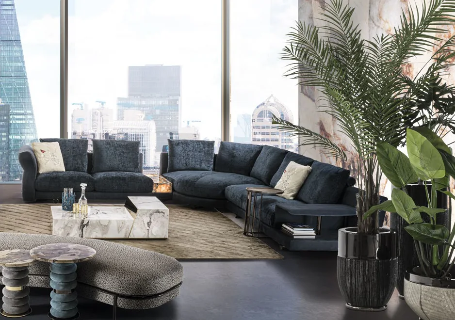 Modern living room with dark blue velvet sectional sofas, marble tables and a city view