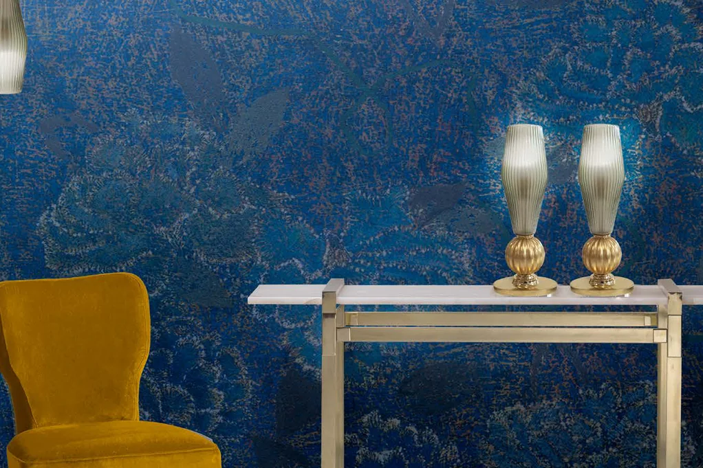 Villari Home Couture catalogue: two glass and gold table lamps on a console against a blue wall